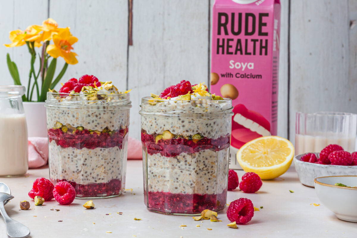 A close-up shot of lemon raspberry overnight oats showing the texture of rolled oats and fresh fruit toppings.
