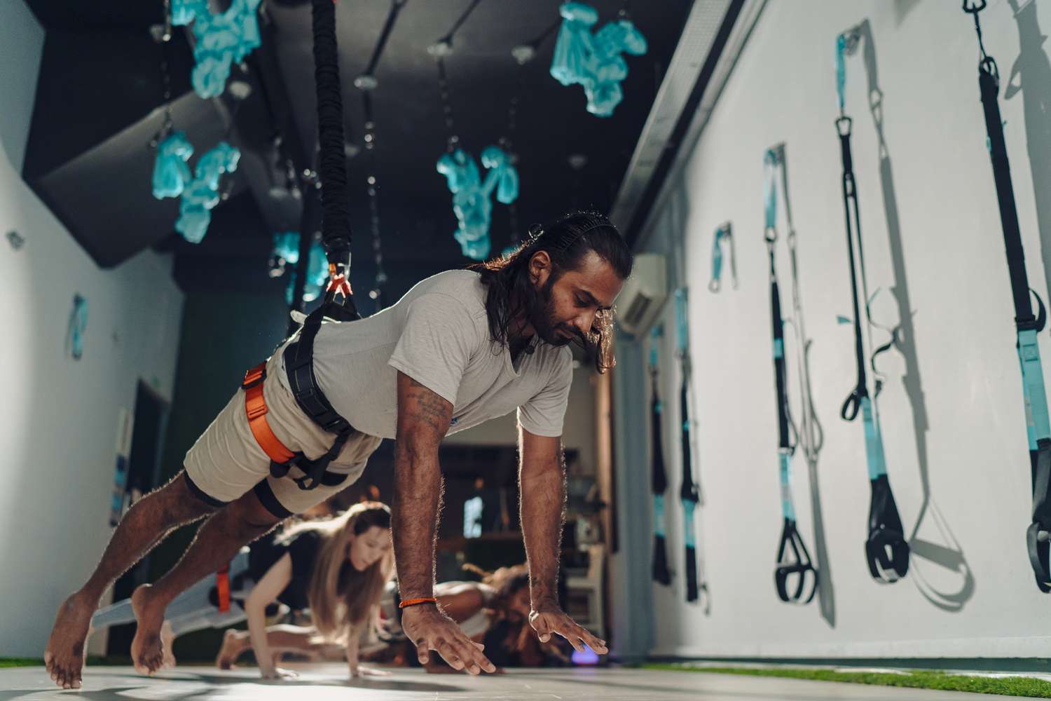 A man performing a suspended plank to demonstrate core stability and the mechanics of suspension exercise.
