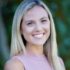 A smiling fitness professional in a wellness-focused setting, conveying warmth and expertise.