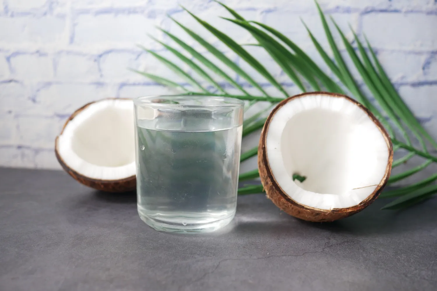 Fresh coconut water served in a coconut with a straw.