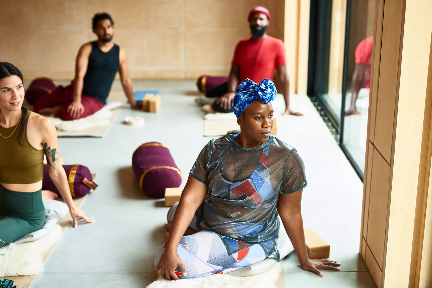 A woman in a seated spinal twist pose during a yoga class.