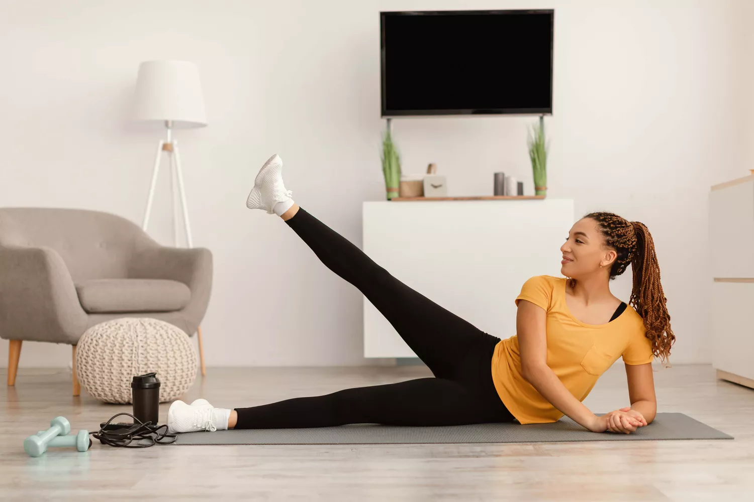 A person lying on their side performing side leg raises.