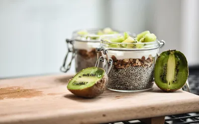 Two jars of chia seed pudding topped with fresh kiwi slices.