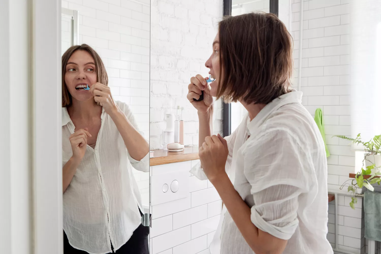 A woman in her bathroom performing her daily health and hygiene routine.