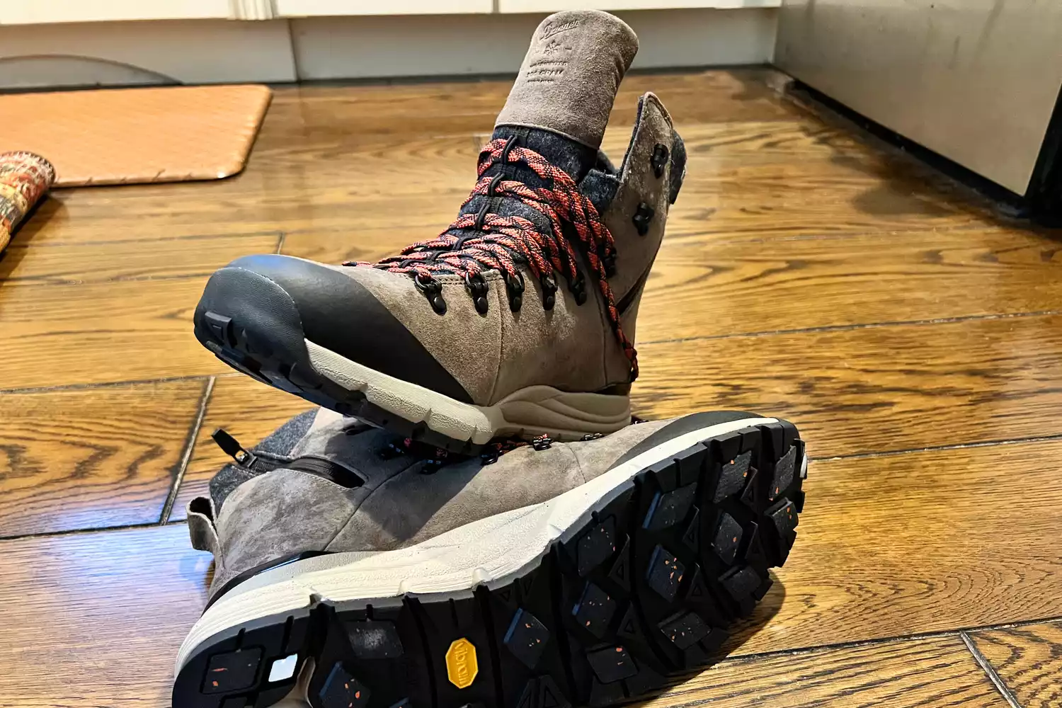 Danner Arctic 600 side-zip hiking boots with Vibram soles on a wooden floor.
