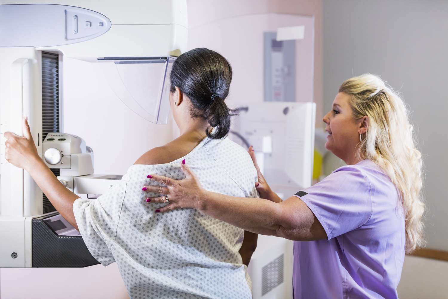 A healthcare professional assisting a patient in a clinical setting during a medical screening.