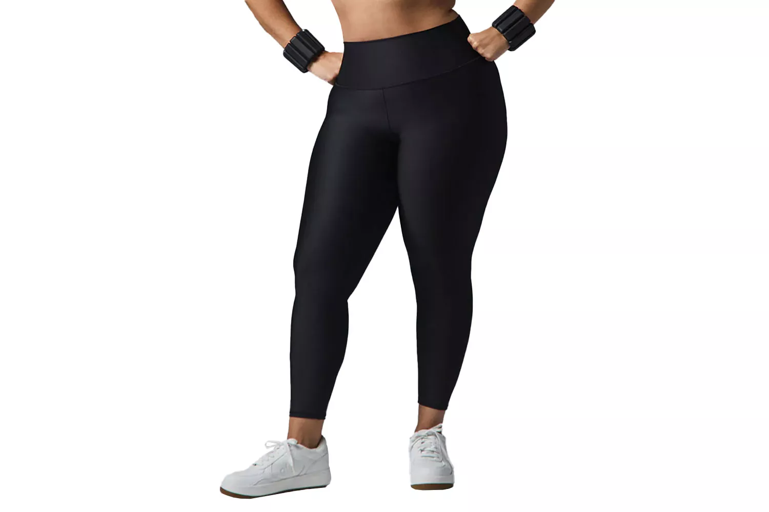 A woman modeling black high-waisted workout leggings that hit perfectly at the ankle without bunching.