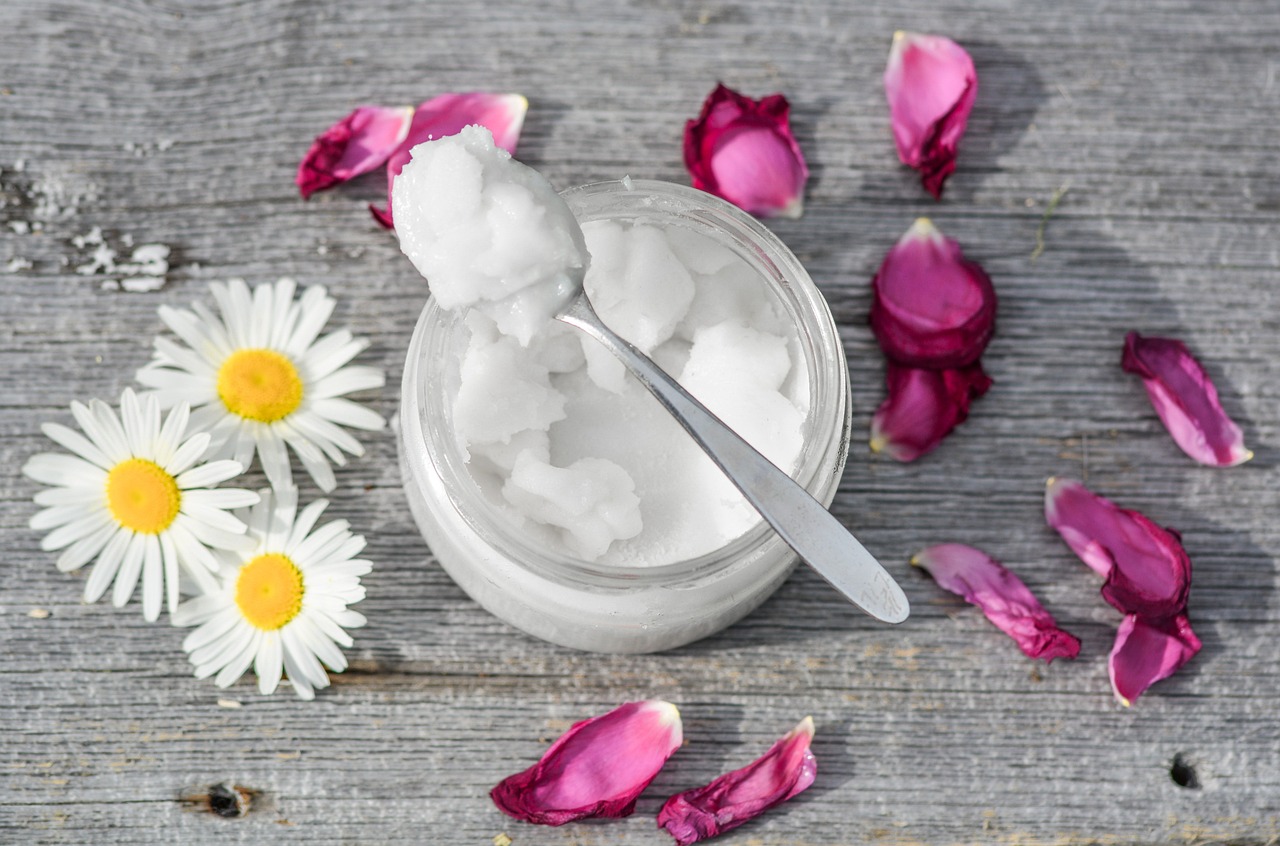 A jar of organic coconut oil with a spoon, used to grease the rice cooker pot.