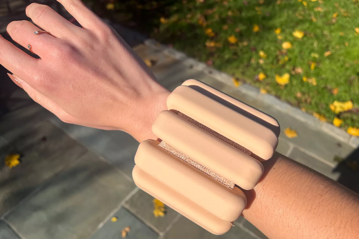 A person wearing a pastel-colored Bala Bangle weight around their wrist.