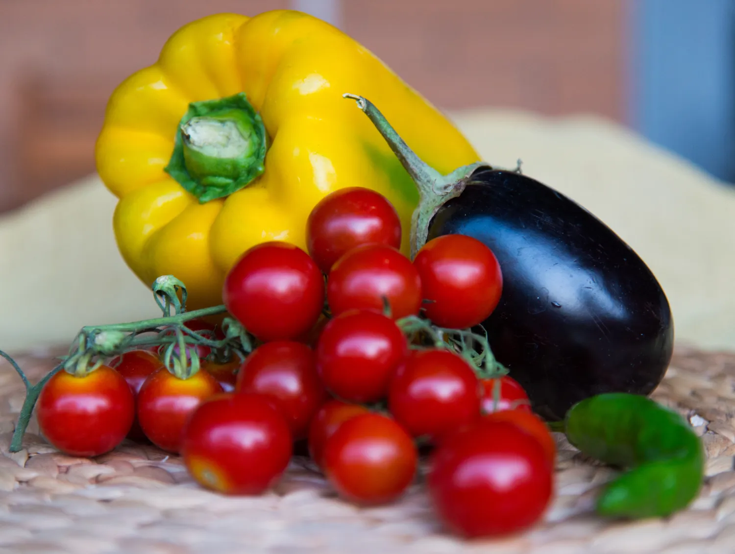 A variety of nightshade vegetables including red tomatoes, purple eggplant, and bell peppers.
