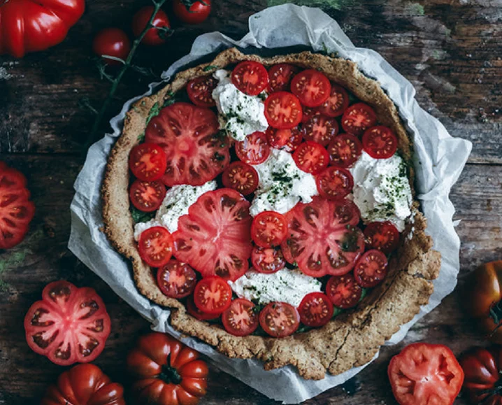 A pre-baked golden-brown sesame cracker crust in a tart tin.