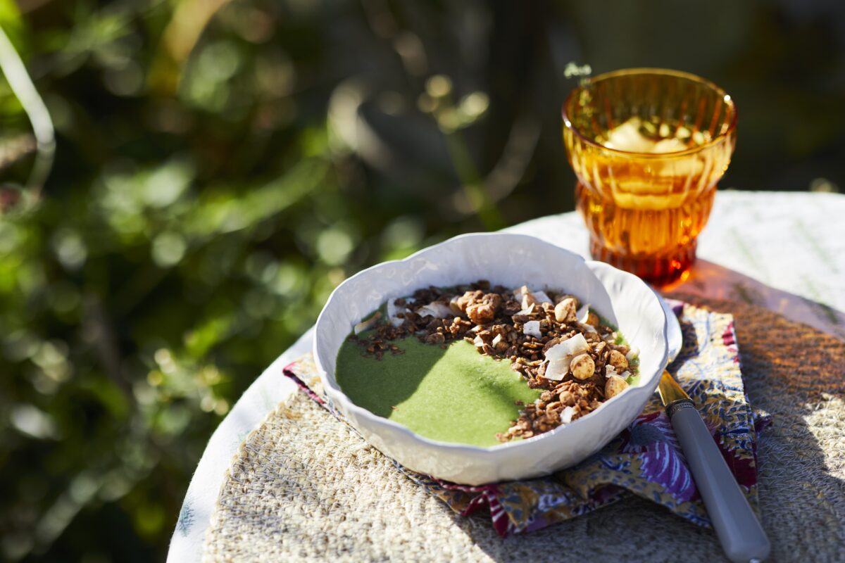 Close-up of a nutrient-dense vegan green smoothie bowl with a thick consistency and colorful toppings.