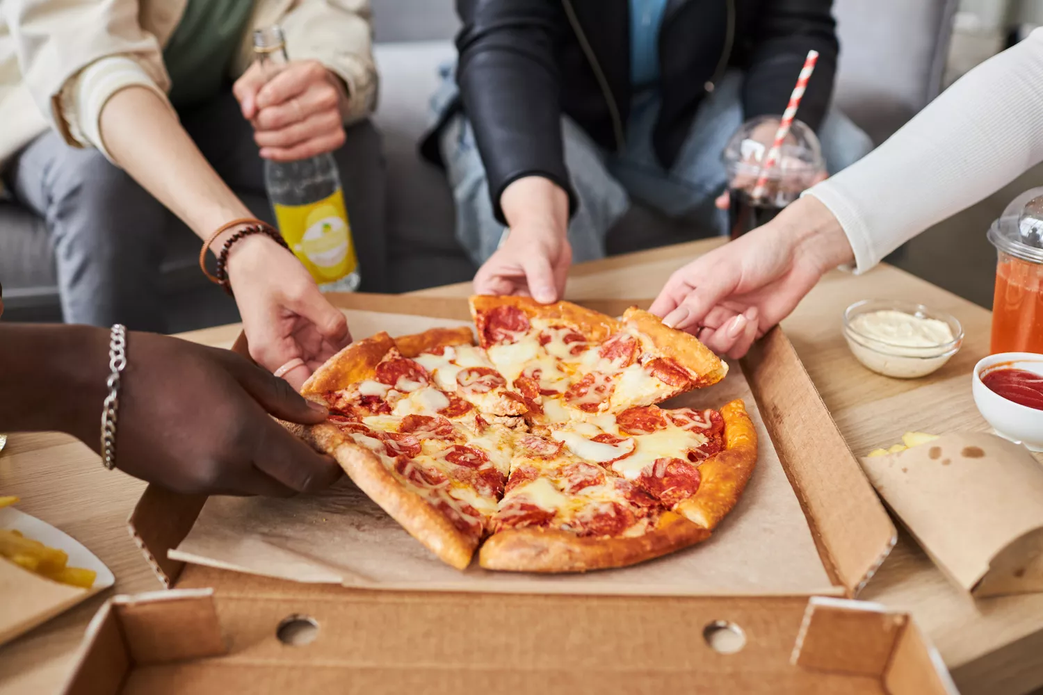 A group of friends sharing a large pizza during a social dinner.