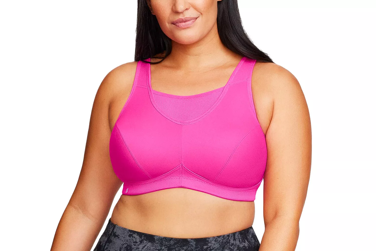 A woman modeling a bright pink plus-size sports bra against a clean white background.