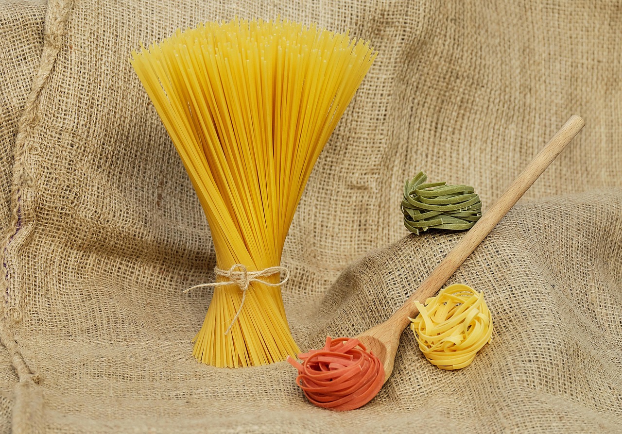 Different types of dry oats including rolled and steel-cut in wooden spoons.