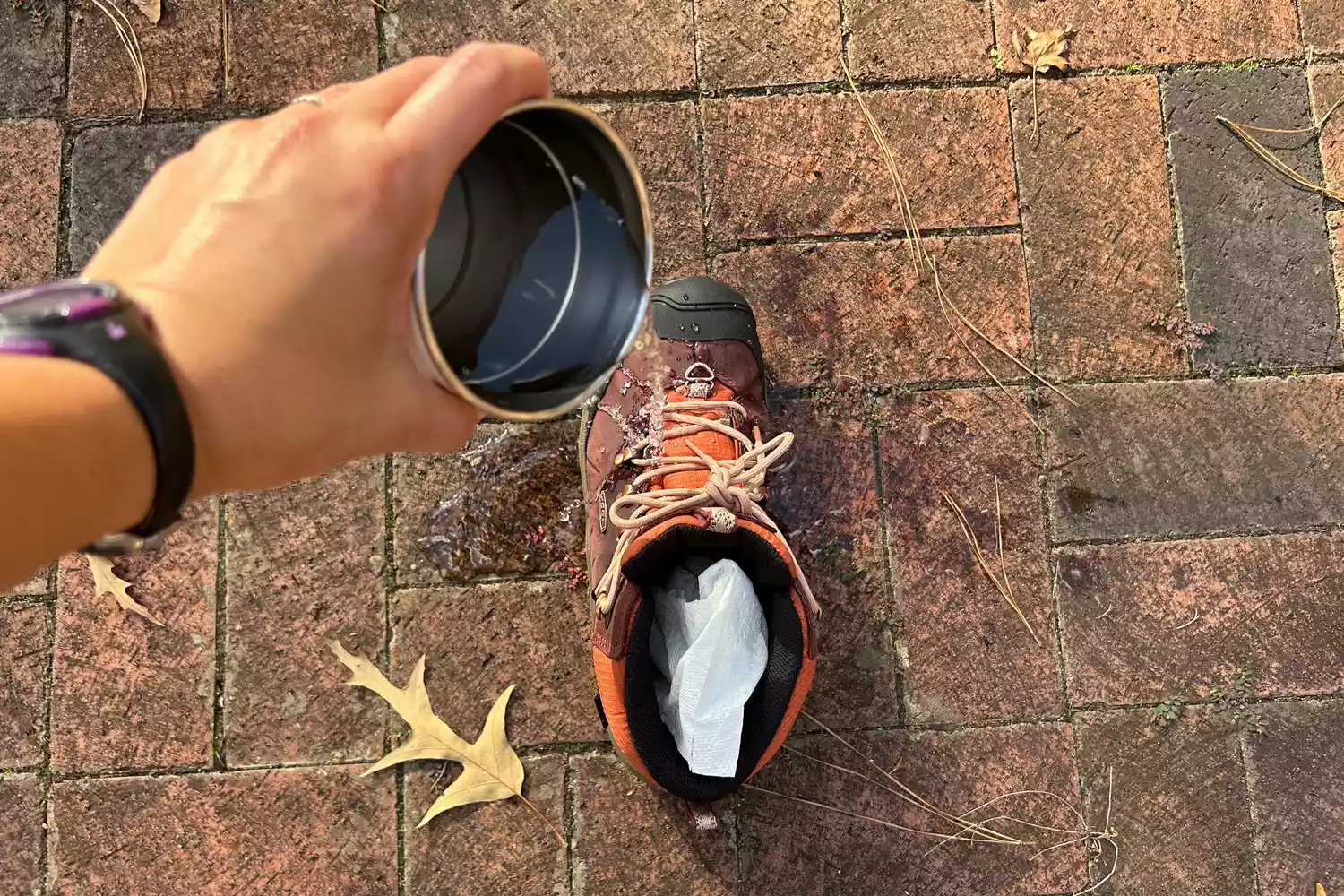 Water being poured into a Keen hiking boot to test for waterproofing.