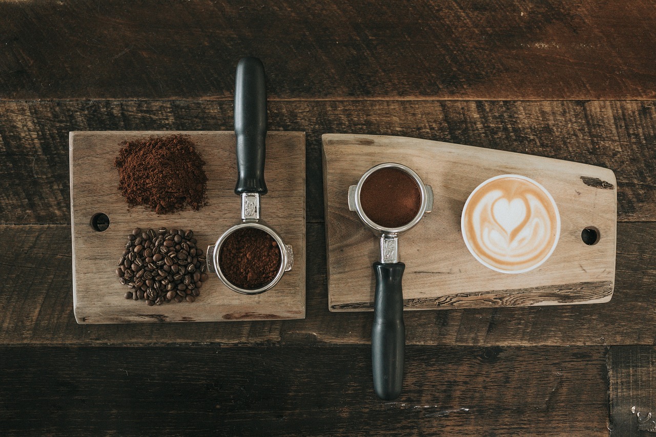 A handheld electric frother creating thick micro-foam in a glass of coffee