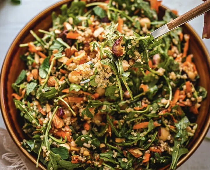 High-protein plant-based quinoa salad featuring grated carrots and fresh mint.