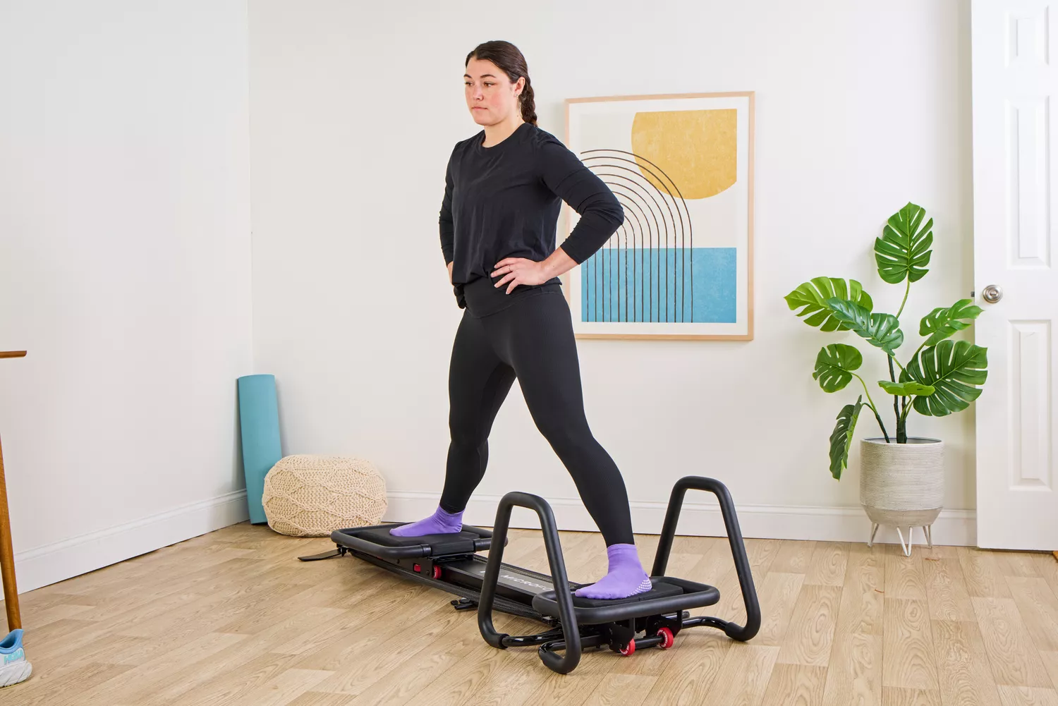 A person exercising on the compact Lagree Micro Reformer.