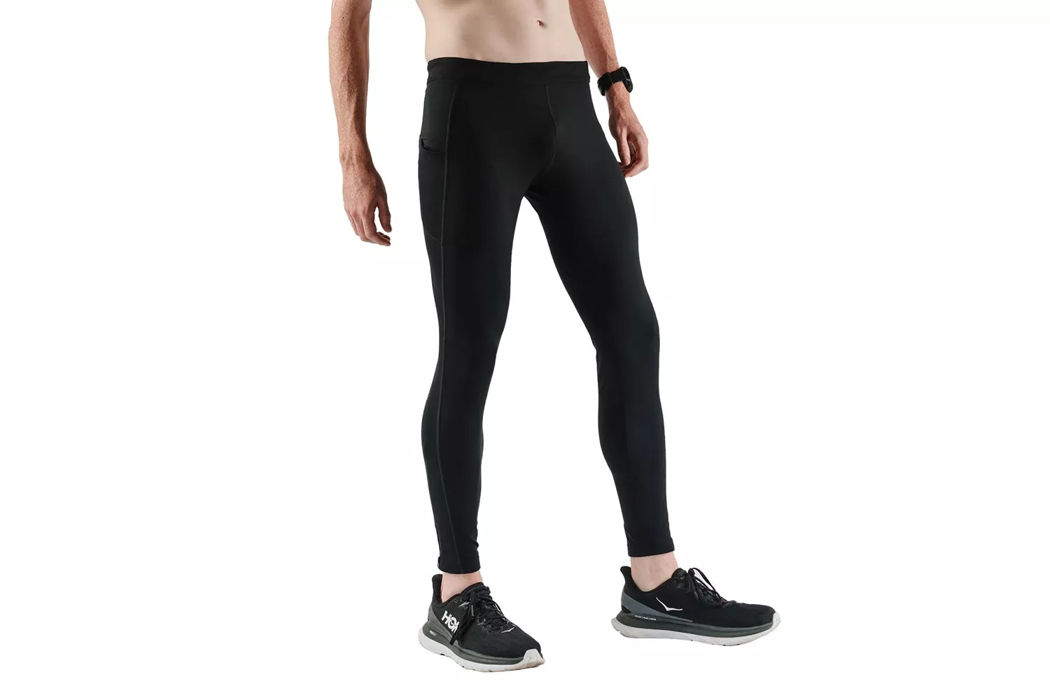 A male model in black compression running tights with side pockets and running shoes.