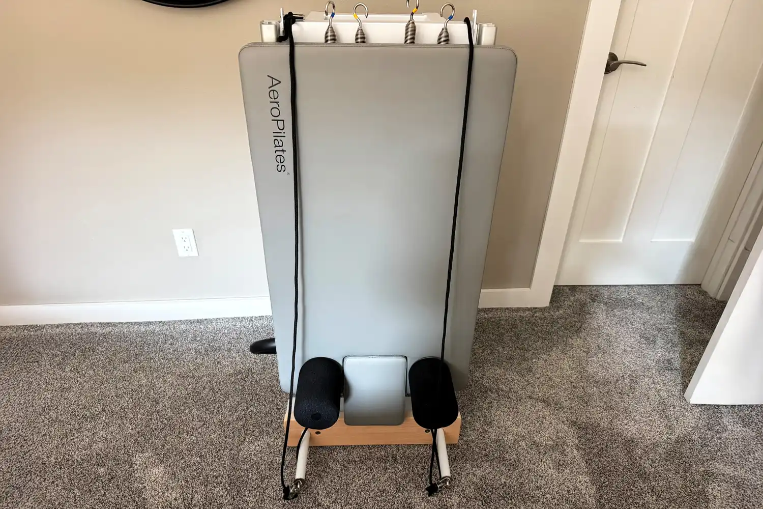 The AeroPilates Precision Series Reformer 610 folded vertically against a wall.